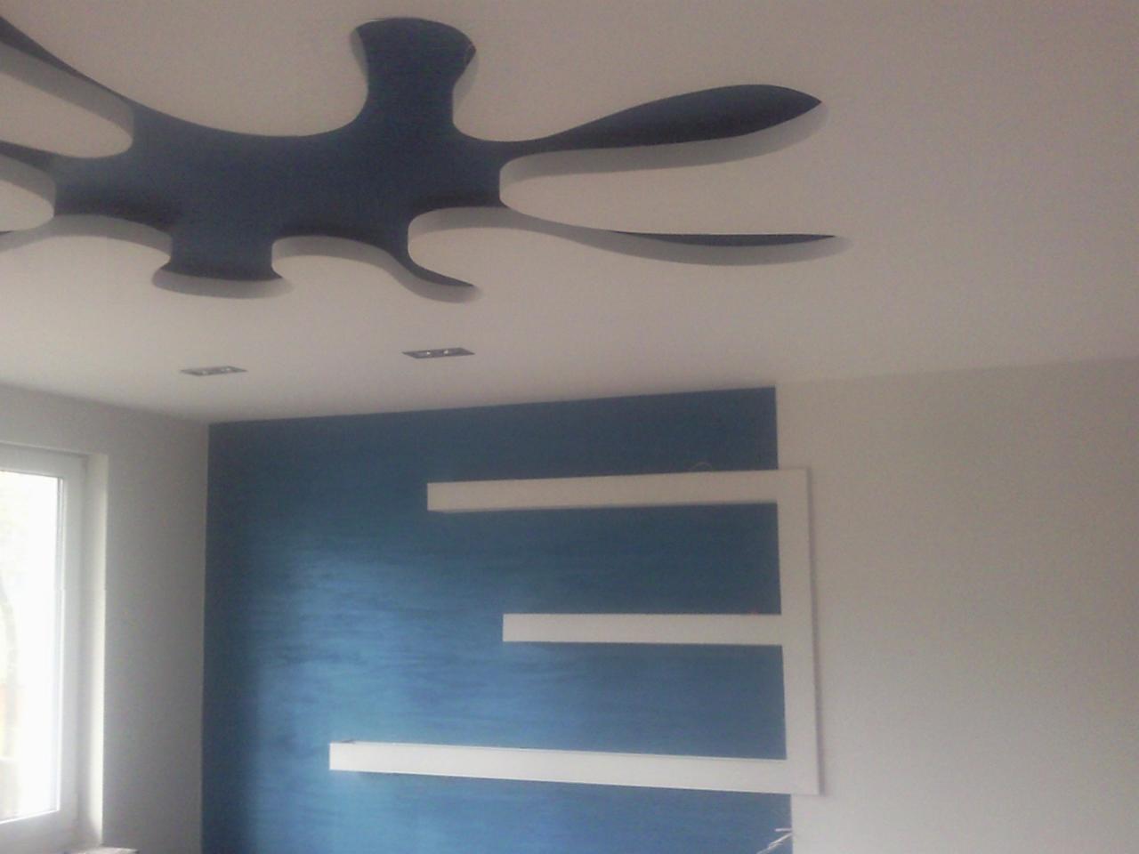 Aranżacja wnętrza w Łodzi z dekoracyjnym, ciemnoniebieskim akcentem na ścianie i suficie, uzupełniona białymi, poziomymi elementami dekoracyjnymi.