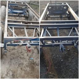 AkorTech - Dwa ujęcia ramy przyczepy: zardzewiała przed i świeżo pomalowana na szaro po piaskowaniu i malowaniu, widoczne elementy zawieszenia i haki holownicze.