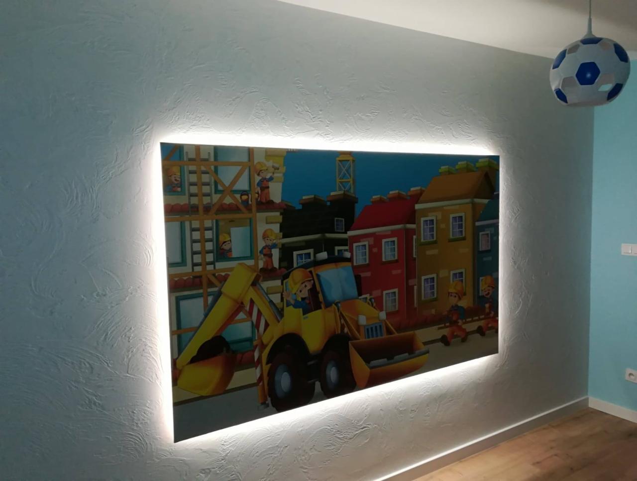 Podświetlony obrazek z motywem budowlanym w pokoju dziecięcym, ściana z fakturą, lampa w kształcie piłki.