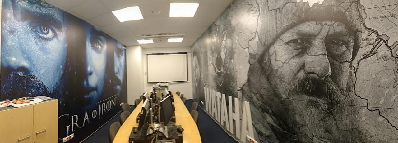 Wnętrze biura we Wrocławiu z fototapetami przedstawiającymi motywy filmowe i mapę, zaprojektowane w ramach identyfikacji wizualnej firmy.