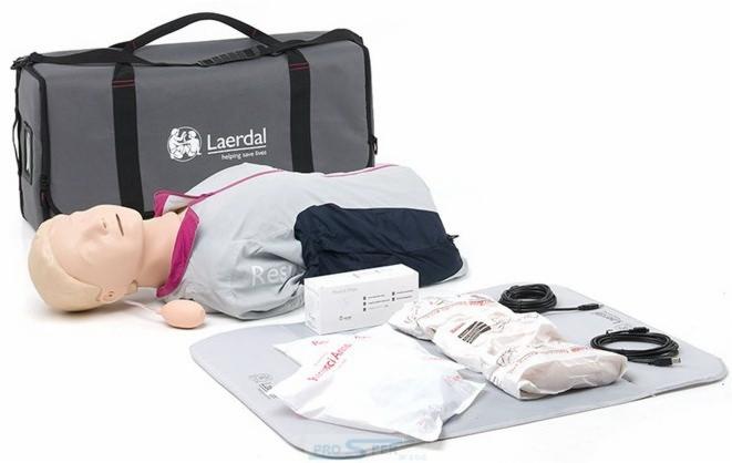 Manekin do ćwiczeń resuscytacji krążeniowo-oddechowej Laerdal na szarej macie, obok torba transportowa, pudełko z akcesoriami i kabel USB.