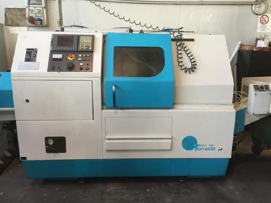 Biało-turkusowa tokarka CNC Tornado z panelem sterowania i osłoną, widoczna w warsztacie.