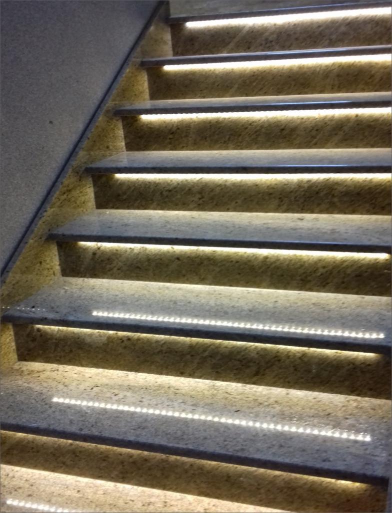 Granitowe schody z subtelnym oświetleniem LED pod każdym stopniem, tworzącym efektowny wizualny akcent.