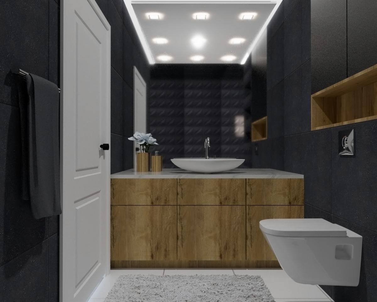 Nowoczesna łazienka z czarnymi płytkami, drewnianą szafką pod umywalką, białym blatem i wiszącą toaletą, oświetleniem LED w suficie i dekoracyjnymi akcentami w postaci kwiatów w złotych wazonach.