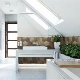Nowoczesna łazienka na poddaszu z drewnopodobną mozaiką heksagonalną na ścianie, białą umywalką nablatową i zielonymi roślinami doniczkowymi, oświetlona światłem dziennym ze skośnego okna dachowego.