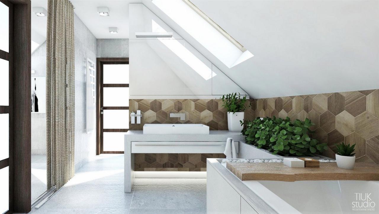 Nowoczesna łazienka na poddaszu z drewnopodobną mozaiką heksagonalną na ścianie, białą umywalką nablatową i zielonymi roślinami doniczkowymi, oświetlona światłem dziennym ze skośnego okna dachowego.