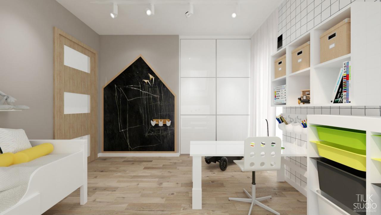 Pokój dziecięcy z białymi meblami, biurkiem, łóżkiem i ścianą z tablicą kredową w kształcie domku, uzupełniony o szafę z przesuwnymi drzwiami.