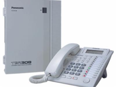 Biała centrala telefoniczna Panasonic TER308 z telefonem systemowym, widoczne numery i przyciski funkcyjne.