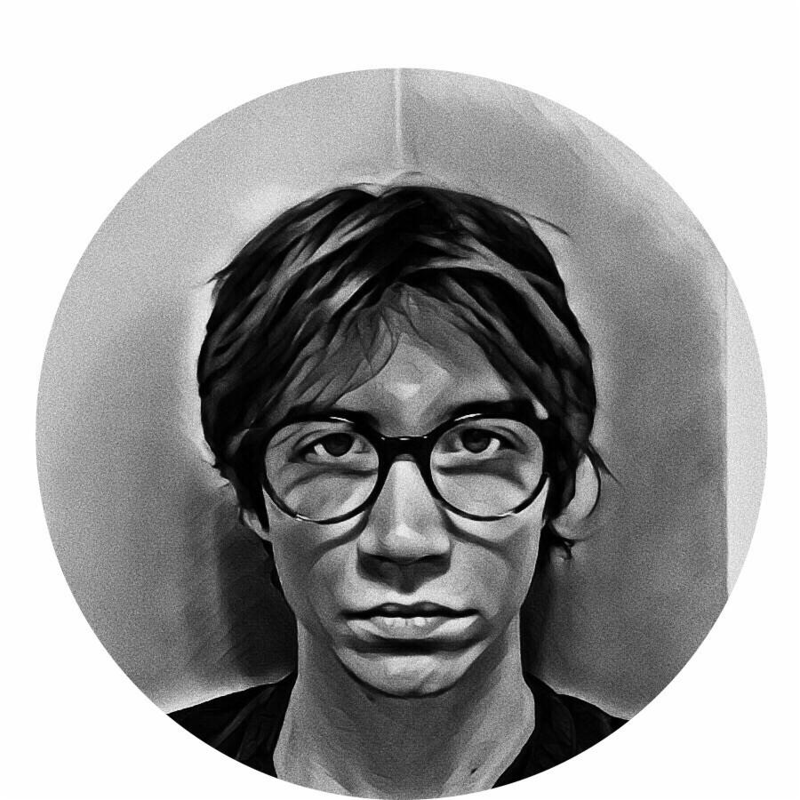 Czarno-biały portret twarzy młodego mężczyzny w okularach, z ciemnymi włosami, na rozmytym tle w kształcie koła.