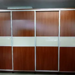 Czterodrzwiowa szafa przesuwna z panelami drewnopodobnymi i mlecznymi, obramowana jasnym metalem.