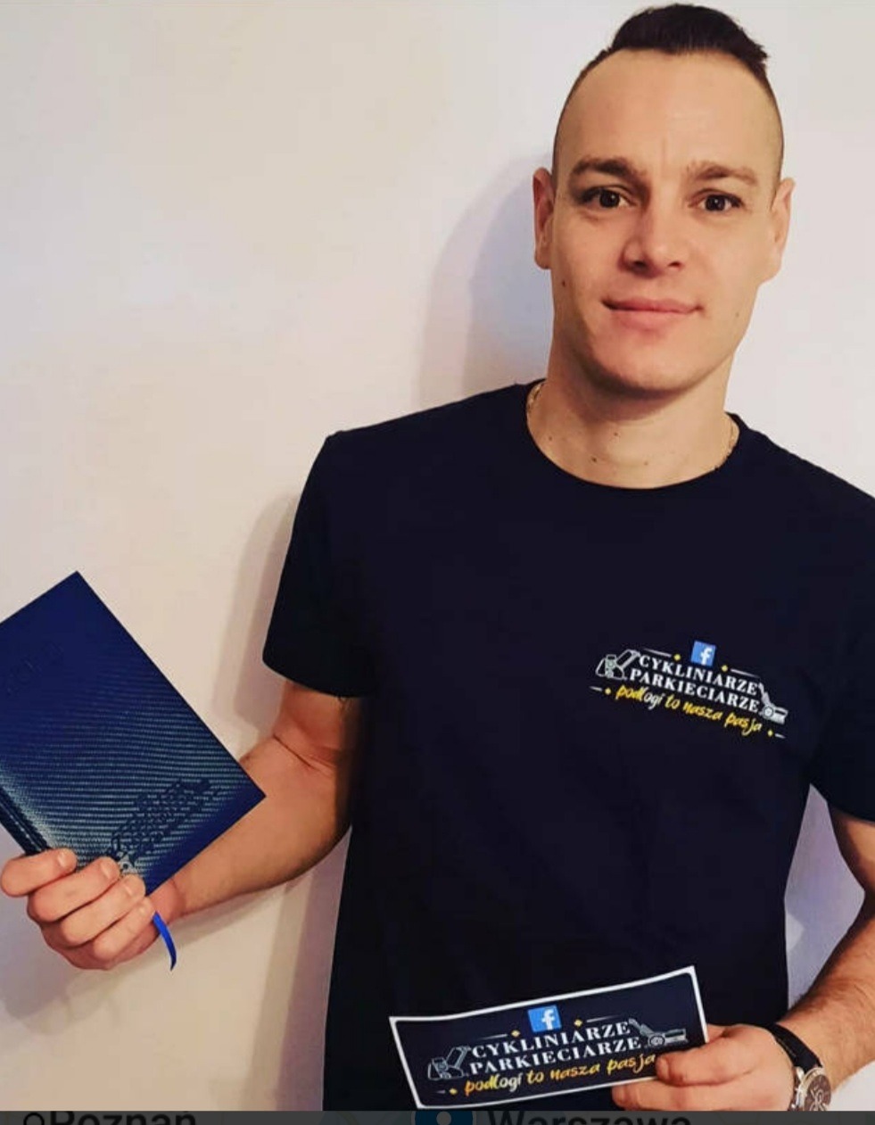Mężczyzna w Słubicach prezentujący firmową koszulkę i folder reklamowy z logo 'Cyklinarze Parkieciarze', podkreślające pasję do podłóg.