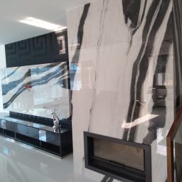 AIRLESS - Nowoczesny salon z błyszczącą podłogą, ścianą z marmuru z kominkiem i czarnym panelem dekoracyjnym na ścianie.