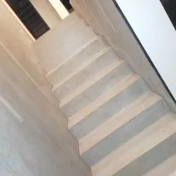 Betonowe schody wewnętrzne z drewnianymi akcentami, widok z góry, nowoczesny design.