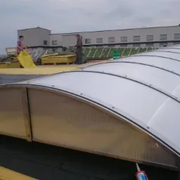 Montaż świetlika dachowego z poliwęglanu na dachu budynku w Ustroniu, widoczni pracownicy i butla gazowa.