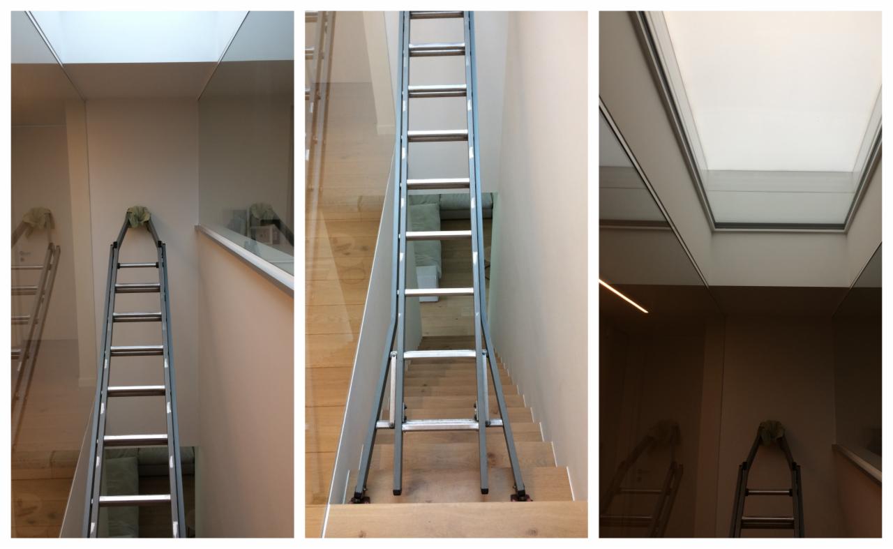 Rozstawiona drabina na schodach w nowoczesnym wnętrzu w Poznaniu, przygotowana do pracy przy oknie dachowym.