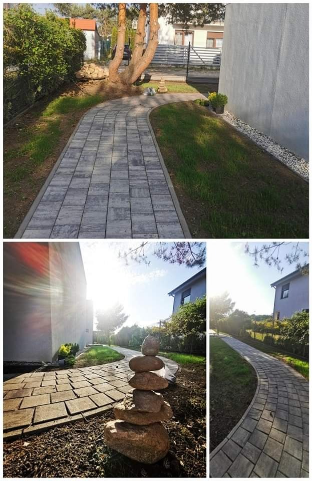 Ścieżka z szarej kostki brukowej wijąca się przez trawnik, z ułożonym stosem kamieni na pierwszym planie i domem w tle.