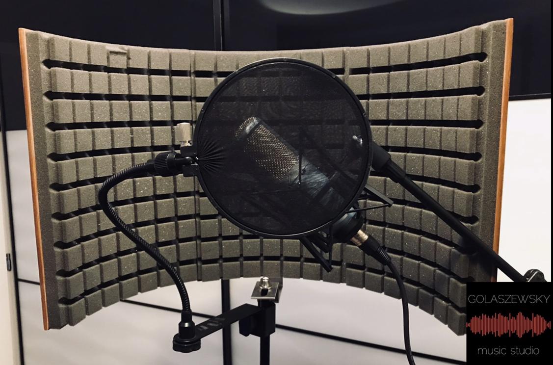 Mikrofon studyjny z filtrem pop i ekranem akustycznym z pianki, ustawiony w zacisznym kącie studia nagrań.