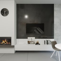 Dekorroom - Nowoczesny salon z kominkiem, zegarem na ścianie, panelem dekoracyjnym za telewizorem i minimalistyczną białą szafką RTV z dekoracjami, uzupełniony okrągłym stołem z krzesłami.