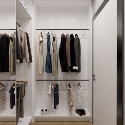 Dekorroom - Wnętrze garderoby z ubraniami wiszącymi na wieszakach, oraz butami stojącymi na półce pod nimi, widok na drewnianą podłogę i białe ściany.