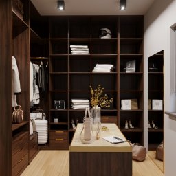 Dekorroom - Projekt garderoby z ciemnego drewna z otwartymi półkami, oświetleniem punktowym, torebkami i odzieżą, uzupełniony o lusterko i roletę okienną.