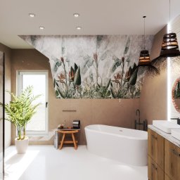 Dekorroom - Nowoczesna łazienka na poddaszu z wolnostojącą wanną, roślinnym motywem na ścianie i drewnianą szafką pod umywalkę. Widoczny stołek i doniczka z palmą przy oknie.