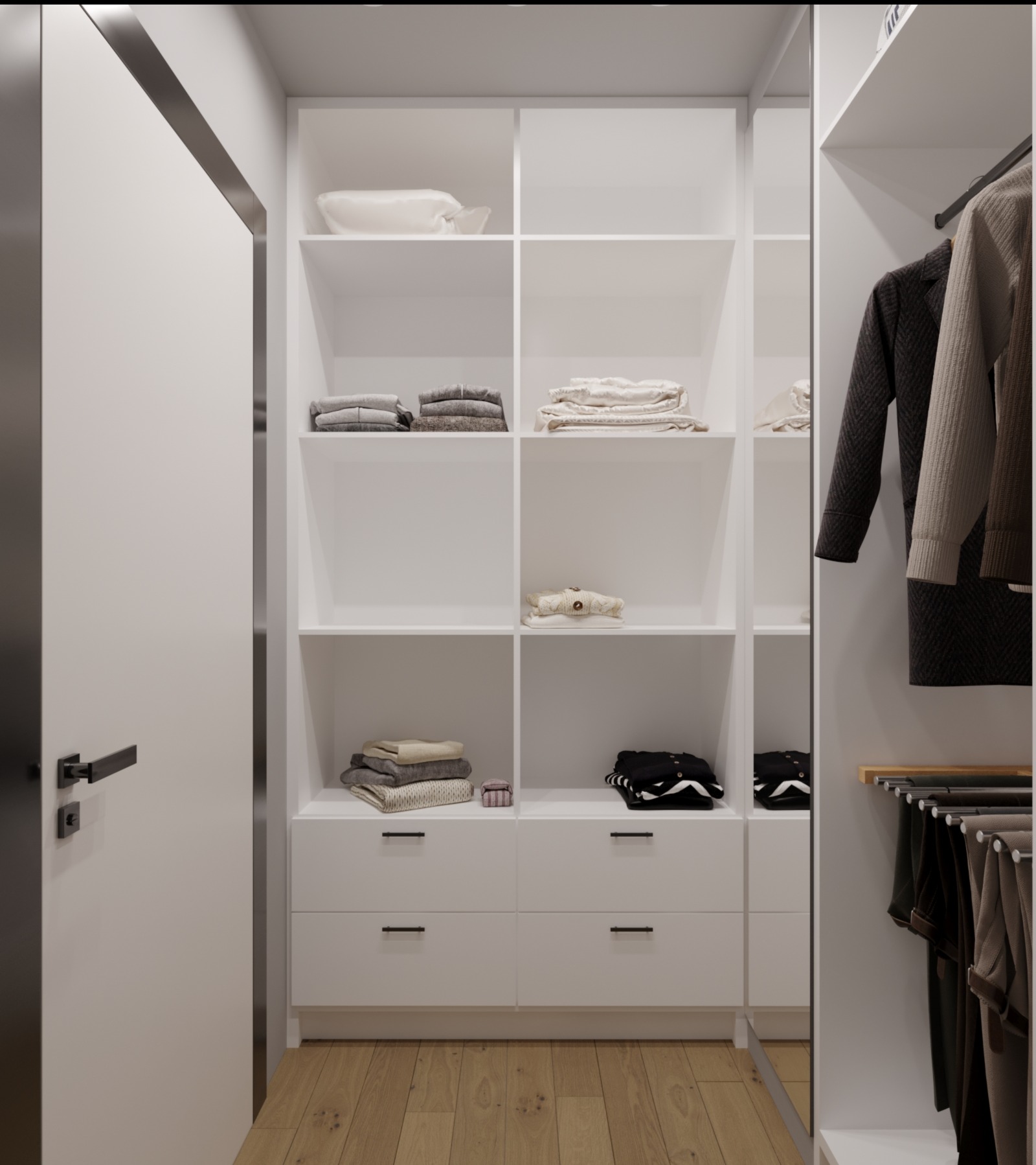 Wnętrze garderoby z białymi półkami i szufladami, widoczne ubrania złożone na półkach i wiszące na wieszakach, drewniana podłoga, minimalistyczny design, czarne uchwyty szuflad i klamka drzwi.