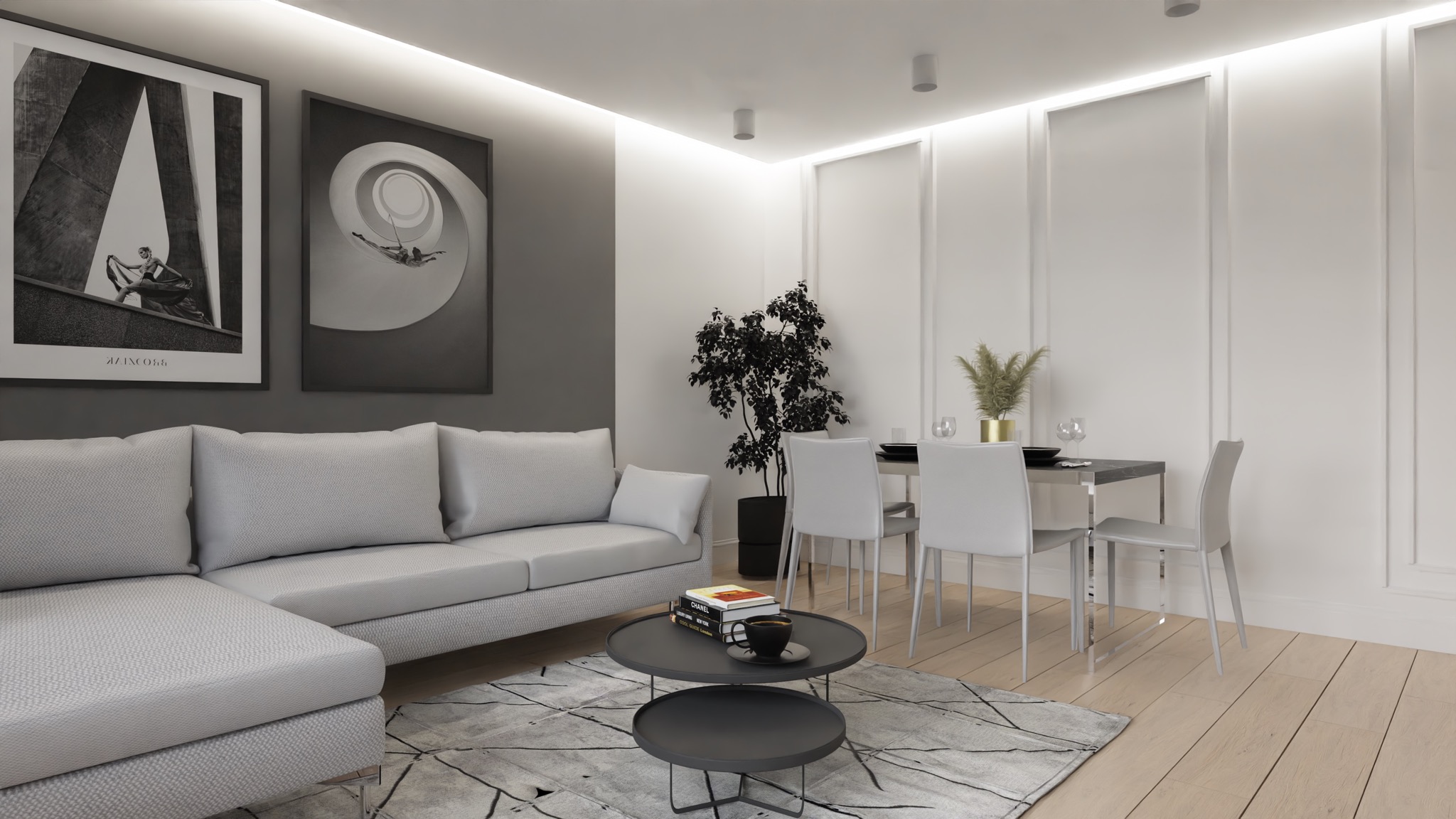 Nowoczesny salon z szarą sofą narożną, okrągłym stolikiem kawowym na dywanie w geometryczne wzory, czarno-białymi grafikami na ścianie i stołem jadalnym z krzesłami w tle.