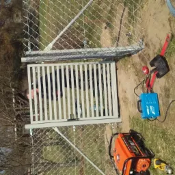 Montaż furtki z pionowych profili do siatki ogrodzeniowej, widoczny agregat prądotwórczy i spawarka inwertorowa.