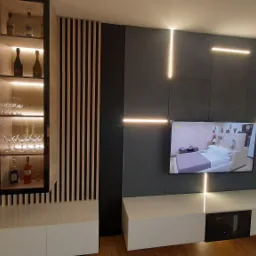 Nowoczesna ściana telewizyjna z podświetleniem LED, szafką RTV i witryną na alkohol, minimalistyczny design z drewnianymi lamelami.