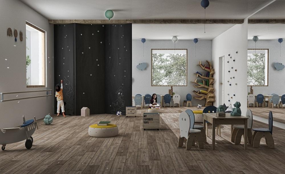 Jasne wnętrze pokoju dziecięcego z drewnianą podłogą, ścianą tablicową, stolikiem z krzesłami w pastelowych kolorach, zabawkami i dekoracjami ściennymi w kształcie kropek i chmurek; dziecko rysuje...