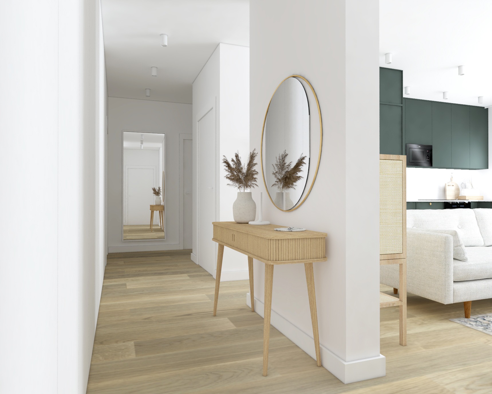 Jasny przedpokój z drewnianą konsolą, okrągłym lustrem w złotej ramie i dekoracyjnym wazonem z suszem; w głębi widoczne lustro, fragment kuchni z zielonymi szafkami i biała sofa.