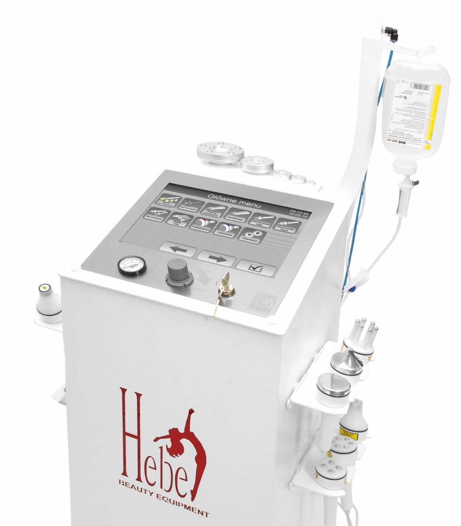 Biały aparat kosmetyczny z ekranem dotykowym, butelką z płynem infuzyjnym i zestawem wymiennych głowic, oznaczony logo Hebe Beauty Equipment.