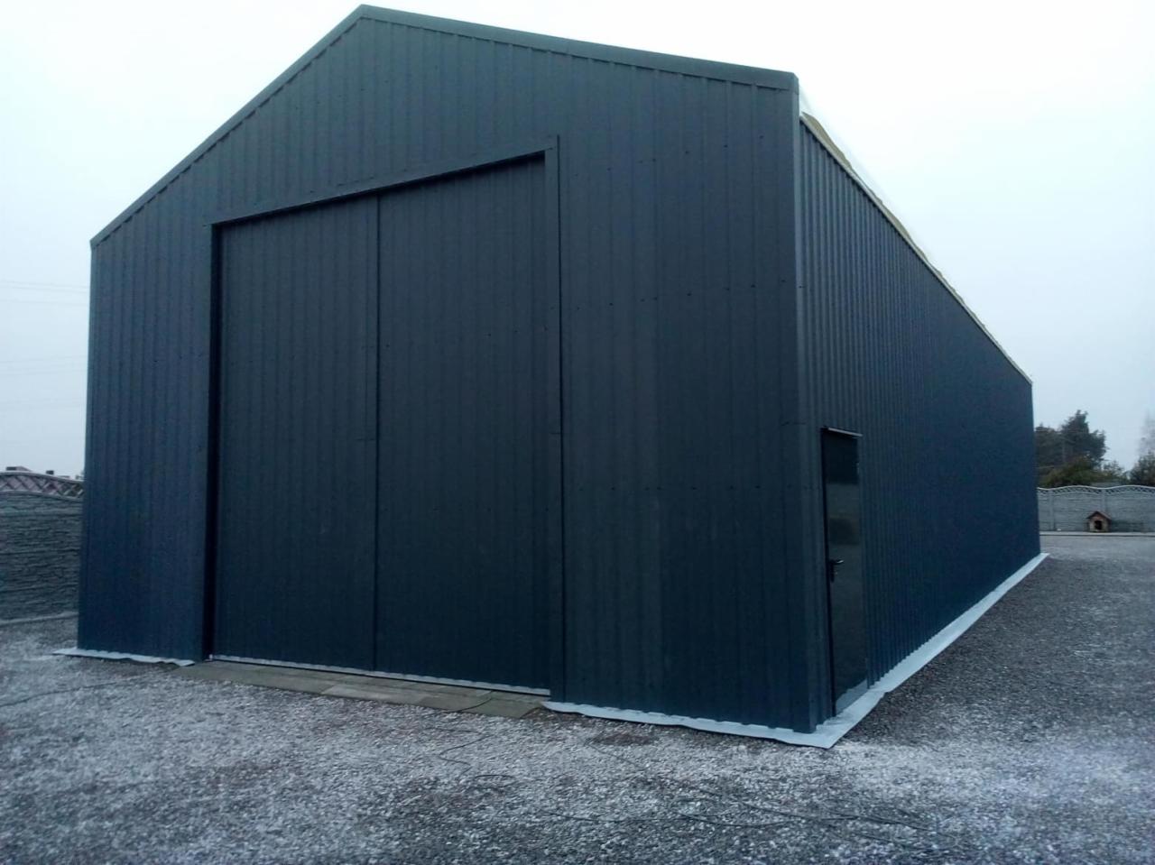 Gotowa hala z blachy trapezowej w Koninie, z dużą bramą przesuwną i małym wejściem bocznym, na utwardzonym terenie.