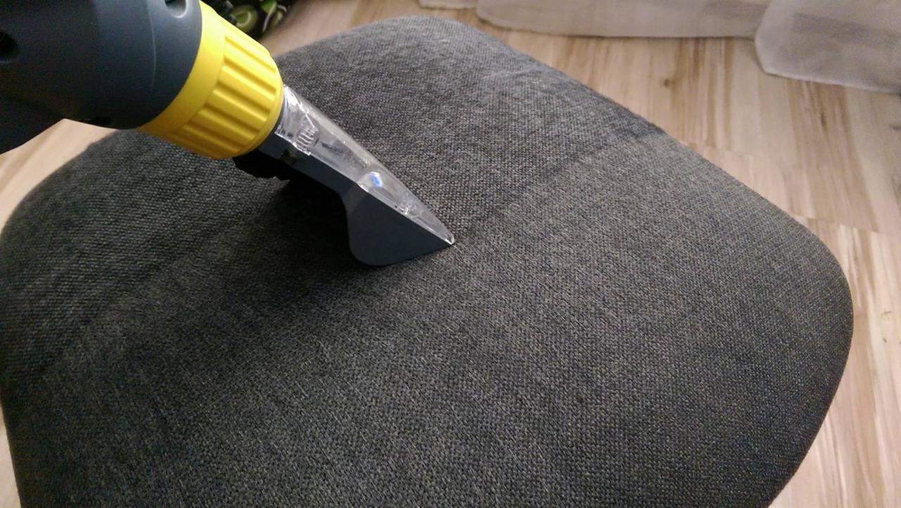Czyszczenie tapicerki krzesła szarą dyszą odkurzacza piorącego, widoczna różnica w odcieniu po prawej stronie.