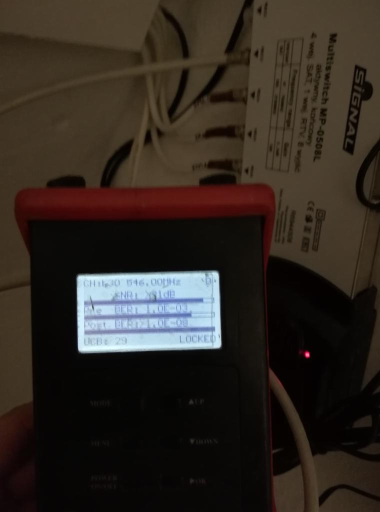 Pomiar parametrów sygnału antenowego za pomocą miernika, widoczny multiswitch i okablowanie