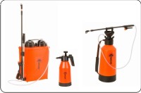 Zestaw trzech pomarańczowych opryskiwaczy ogrodowych: plecakowy z lancą teleskopową, ręczny ciśnieniowy oraz mały ręczny, na białym tle.