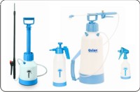 Zestaw opryskiwaczy ogrodowych różnej wielkości, w kolorach białym i niebieskim, stojących na białym tle. Widoczny opryskiwacz ciśnieniowy plecakowy z lancą oraz mniejsze opryskiwacze ręczne.