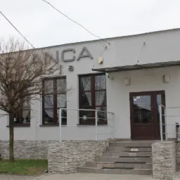 Fasada budynku z napisem 'Casablanca' nad oknami, widoczne schody wejściowe i drzewo bez liści przed budynkiem.