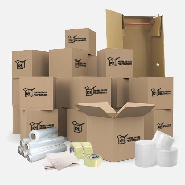 Stos kartonowych pudeł z logo firmy, folia stretch, taśma klejąca i rozłożony kartonowy szafowy pojemnik z czerwonym drążkiem wewnątrz, przygotowane do spakowania rzeczy.