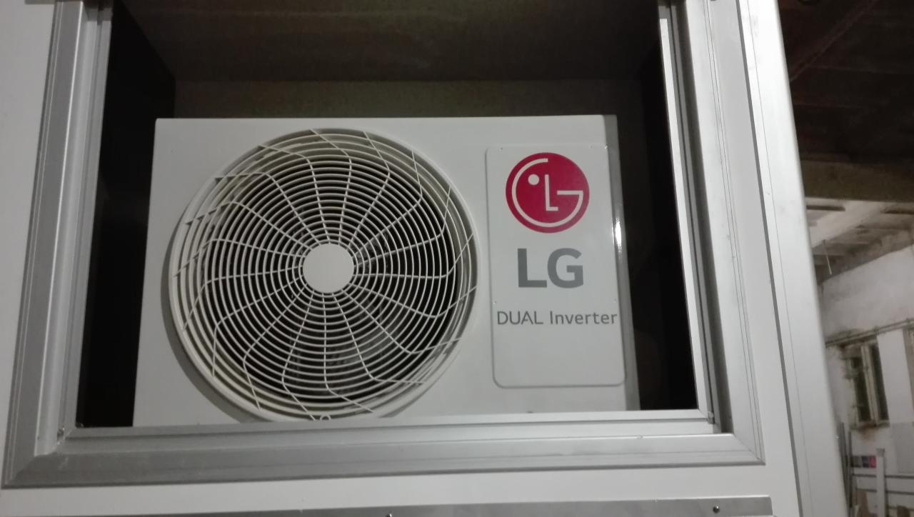 Biała jednostka wewnętrzna klimatyzacji LG Dual Inverter umieszczona w zabudowie, widoczny wentylator i logo producenta.