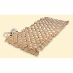 Beżowy materac przeciwodleżynowy z pompką powietrza, widok z góry pod kątem.