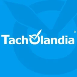 Białe logo Tacholandia na błękitnym tle z symbolem zaznaczenia w miejscu litery 'o'.