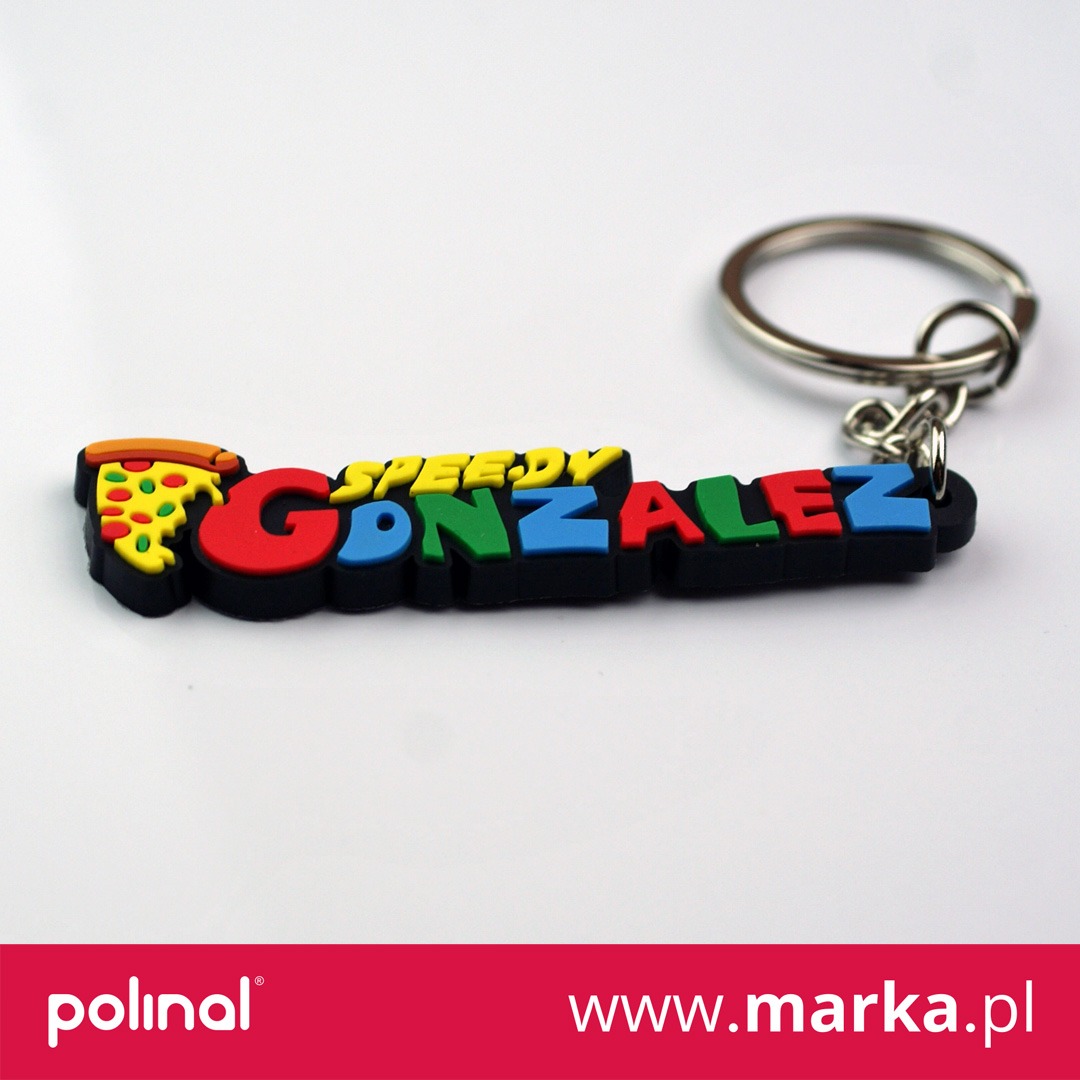 Kolorowy brelok z gumy w kształcie napisu 'Speedy Gonzalez' z elementem pizzy na początku, na białym tle.