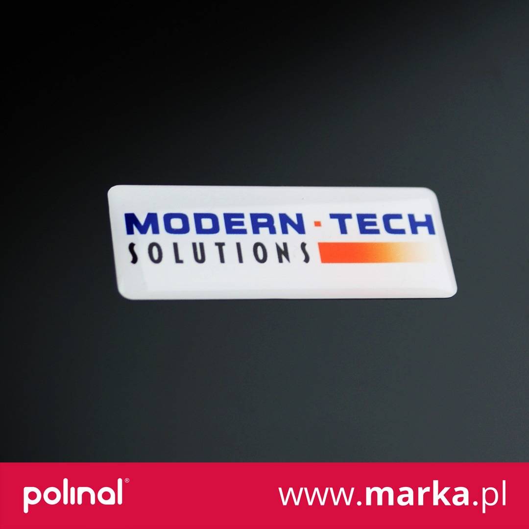 Biała etykieta z napisem 'MODERN-TECH SOLUTIONS' w kolorze niebieskim i pomarańczowym gradientem, leżąca na czarnym tle.