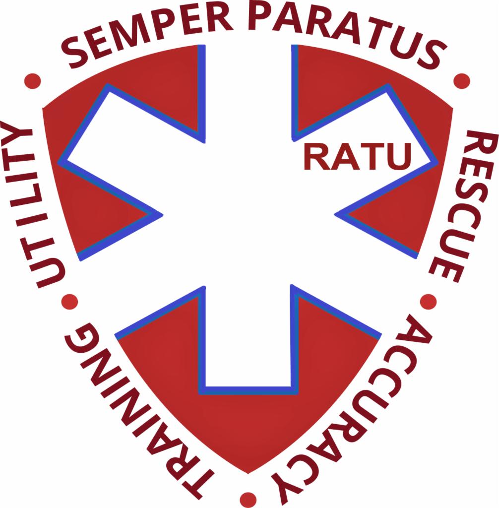 Logo RATU z czerwonym krzyżem obrysowanym na niebiesko, wpisanym w czerwoną tarczę z napisem SEMPER PARATUS na górze oraz TRAINING, UTILITY, ACCURACY, RESCUE na obwodzie tarczy.