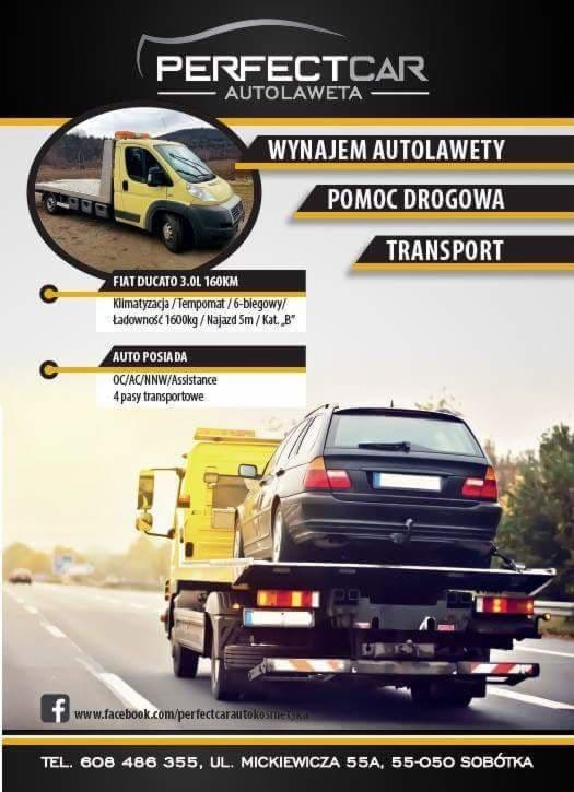 Żółta laweta z czarnym kombi na platformie, widok z tyłu, na banerze reklamowym firmy PerfectCar Autolaweta.