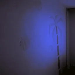 Dekoracyjna ściana z geometrycznymi wzorami i motywem palmy, oświetlona niebieskim światłem, tworząca unikalny efekt wizualny we wnętrzu.