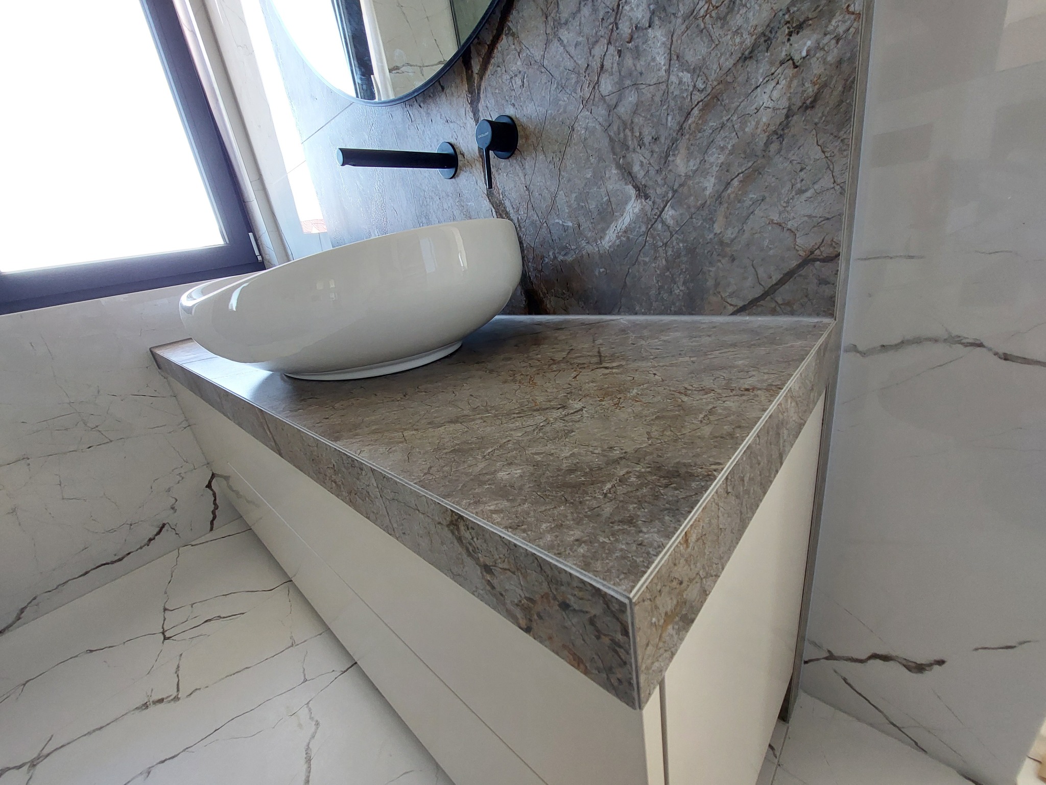 Elegancka umywalka nablatowa w łazience po remoncie w Krzywaczce, z blatem imitującym marmur i baterią w kolorze czarnym.