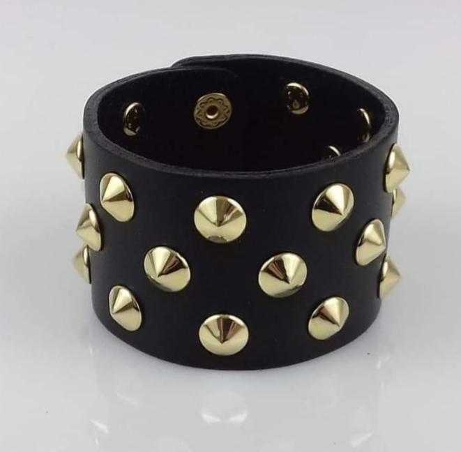 Czarna, skórzana bransoletka z metalowymi, złotymi ćwiekami w kształcie stożków, zapięcie na zatrzask.