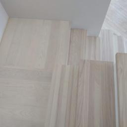 Usługi Parkieciarskie - Jasne, drewniane schody widziane z góry, z delikatnym usłojeniem i minimalistycznym wykończeniem.
